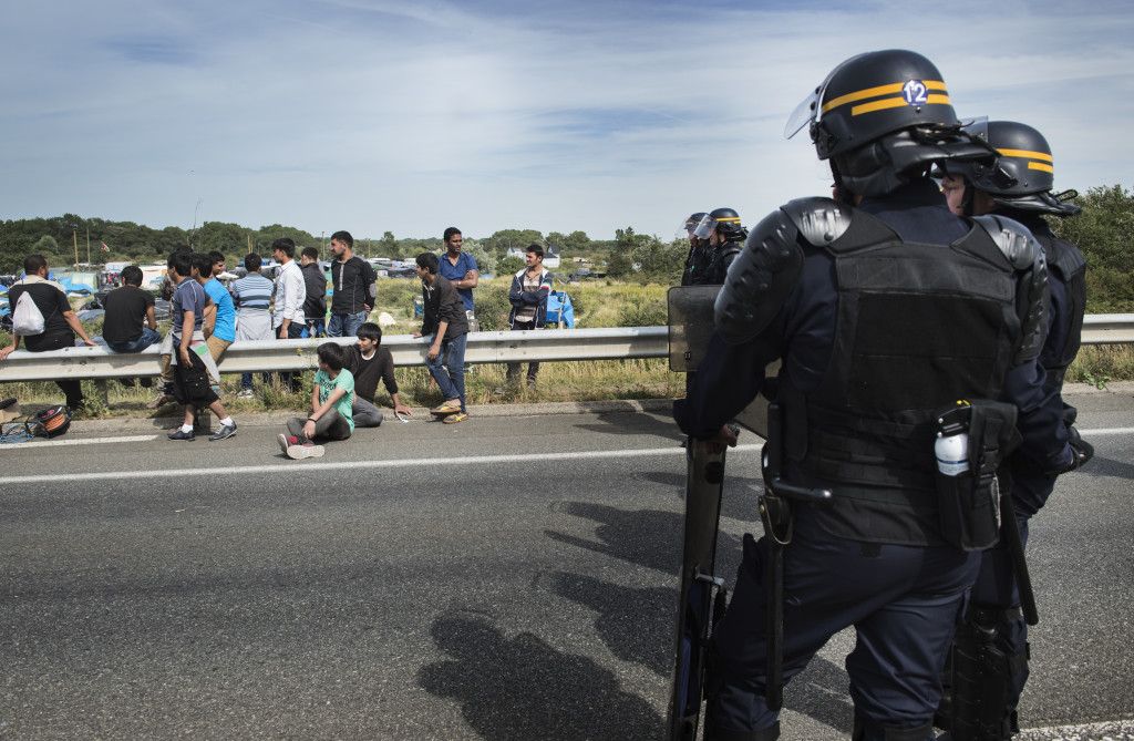 Fransk kravallpolis vaktar vägen utanför flyktinglägret.